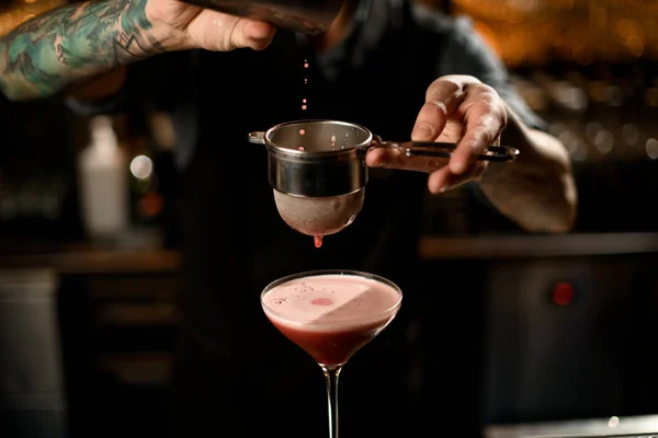 Close-up de bartender derramando bebida através da peneira — Fotografia de Stock