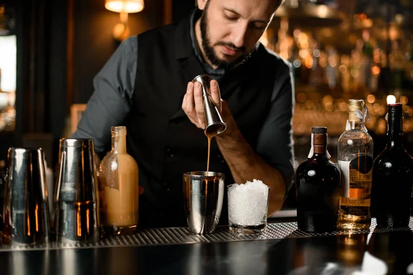 Samec barman nalévání krémový liqour od jigger na ocelové třepačky — Stock fotografie