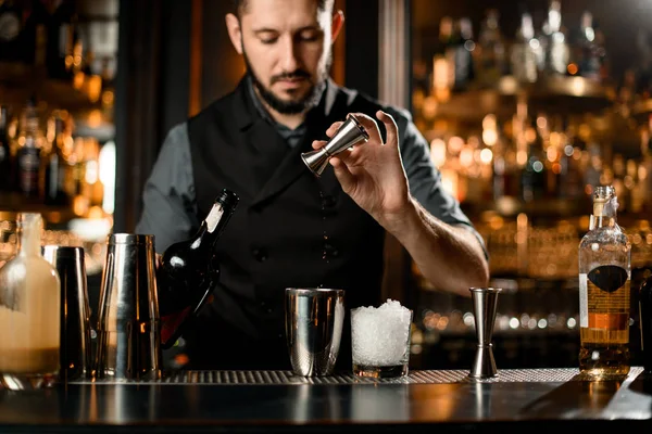 Man barman gieten een liqour van het jigger naar een stalen shaker — Stockfoto