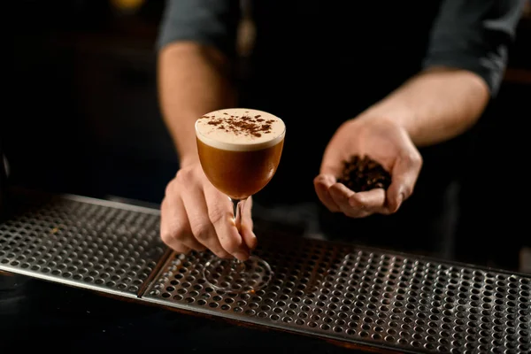 Professionell manlig bartender som serverar den bruna alkoholhaltiga drycken strö på den med kryddor — Stockfoto