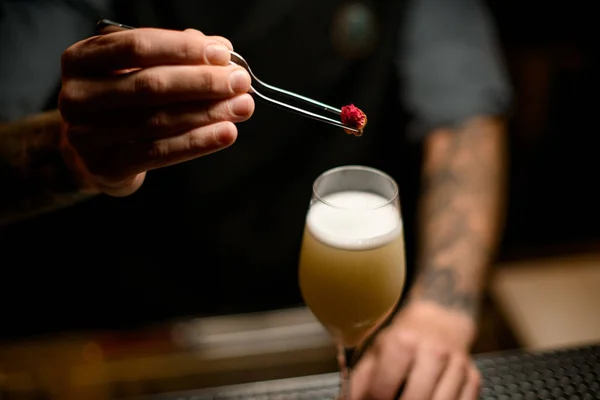 Profesjonalny barman udekorował żółty kremowy napój alkoholowy z odrobiną pączka róży — Zdjęcie stockowe