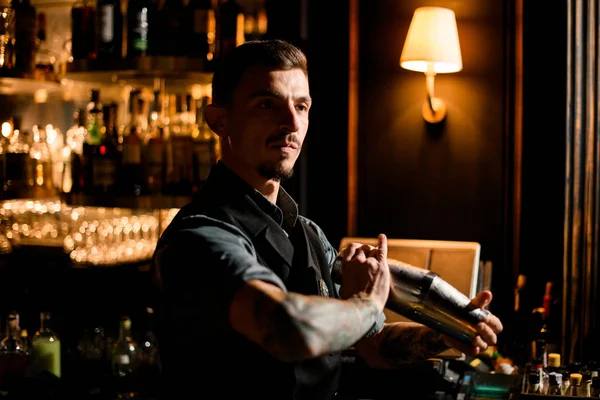 Sakallı bir erkek barmen, elinde bir çelik titretici, barda sallamaya hazır. — Stok fotoğraf