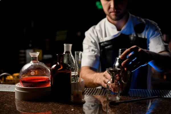 Profesionální barman drží v ruce ocelový třepačka otevřít ji v blízkosti barman zařízení — Stock fotografie