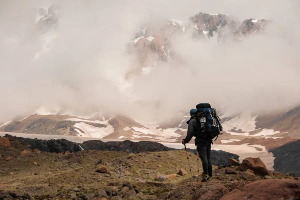 Caminante se encuentra en la cima de la montaña brumosa — Foto de Stock