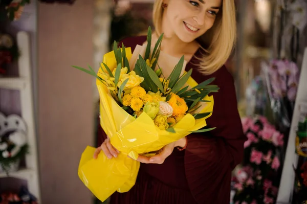 Mujer sonriente con ramo de flores y rosas — Foto de Stock