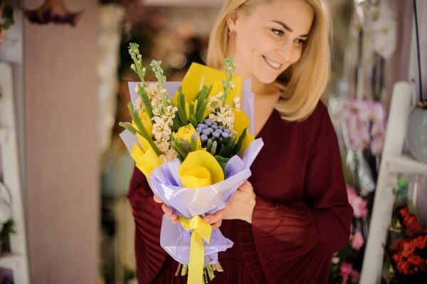 Chica atractiva sosteniendo ramo con tulipanes amarillos — Foto de Stock