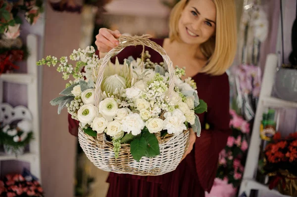 Mulher loira segurando cesta cheia de flores brancas — Fotografia de Stock