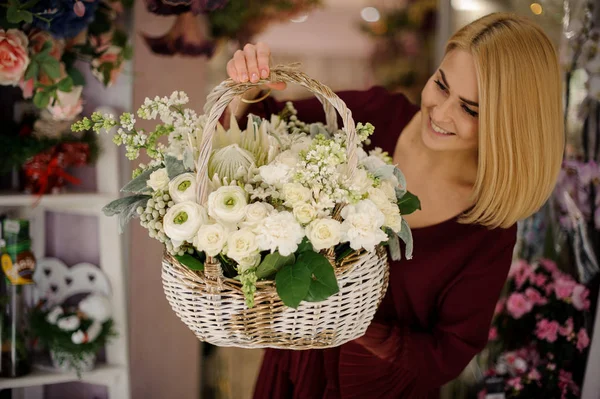 Chica rubia sosteniendo cesta llena de flores blancas — Foto de Stock