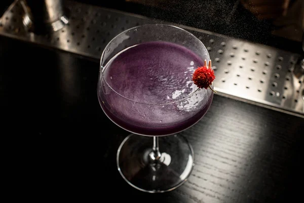 Violettes alkoholisches Getränk im großen Cocktailglas mit roter Blume — Stockfoto