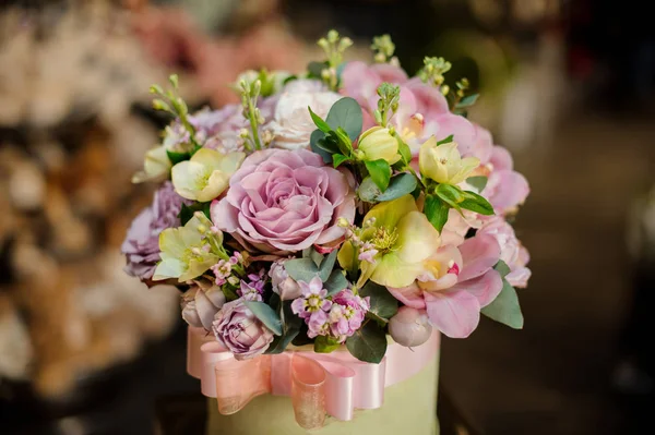 Caja redonda llena de tiernas flores de color púrpura y verde — Foto de Stock