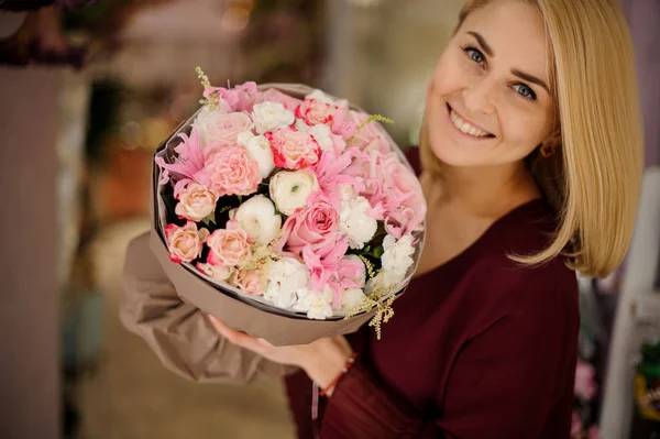 Chica sonriente con exuberante ramo de flores de color rosa — Foto de Stock