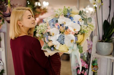 Genç bayan çiçek buketine bakıyor.