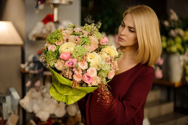 Mujer bien vestida mirando ramo de flores —  Fotos de Stock