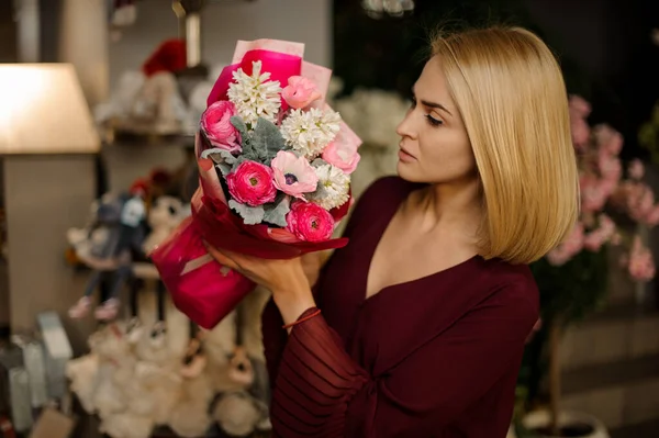 Atractiva chica rubia sostiene ramo de flores — Foto de Stock