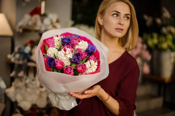 Blonda poser med bukett av pioner och blommor — Stockfoto