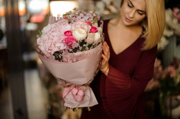 Blonde standing with bouquet of irises and roses — 스톡 사진