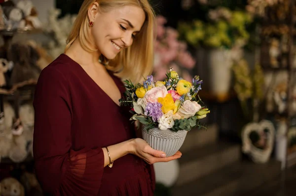 Blondine hält kleinen Strauß in strukturiertem Topf — Stockfoto