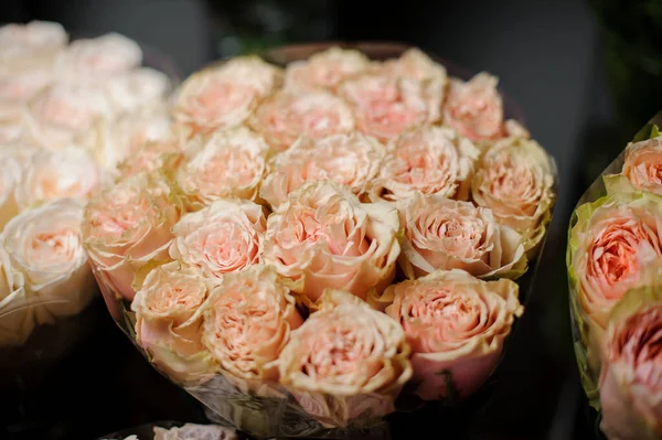 Gyönyörű csokor gyengéd őszibarack színű rózsából az átlátszó csomagolópapírban — Stock Fotó