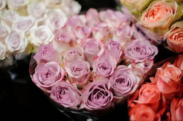 Beautiful bouquet of violet color roses in the transparent wrapping paper