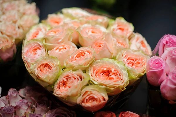 Hermoso ramo de rosas de color melocotón verde tierno en el papel de embalaje transparente —  Fotos de Stock