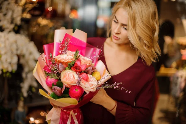 Chica rubia sosteniendo un ramo de primavera de rosas de color rosa y cremoso en el papel de regalo — Foto de Stock