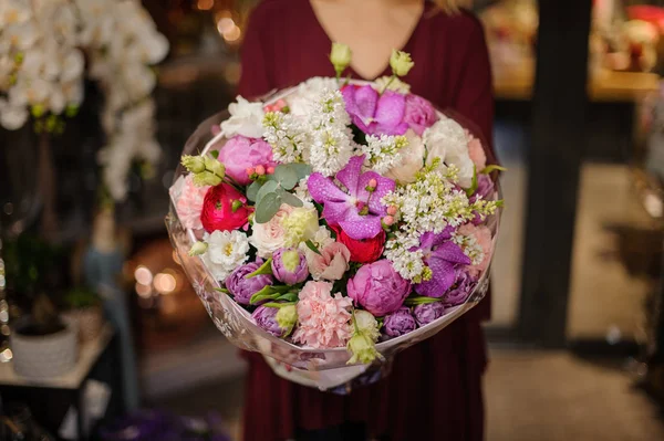 Girl holding a spring bouquet of tender pink, white, red and violet flowers in the wrapping paper — 스톡 사진