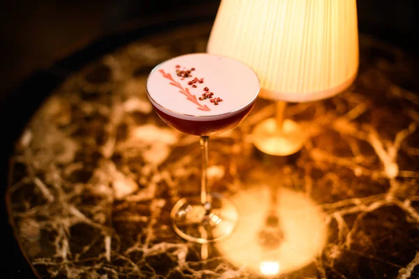 Růžový alkoholický koktejl s bílou špínou zdobený hráškem z červené papriky — Stock fotografie