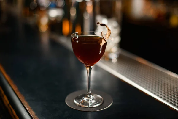 Brauner Cocktail im Glas, dekoriert mit einem getrockneten Blatt durch eine Nadel — Stockfoto