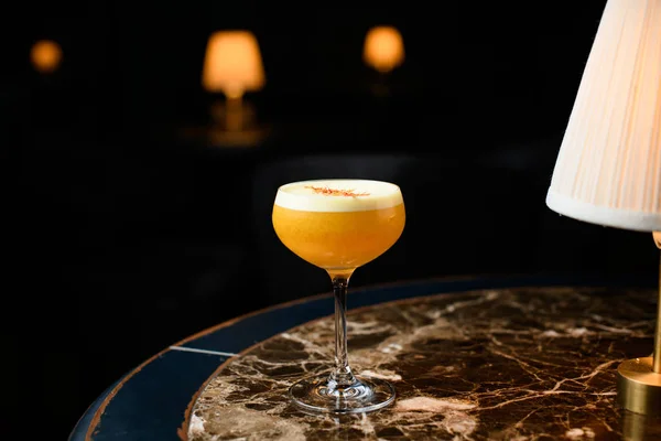 Orange alcoholic cocktail with a white scum decorated with orange zest — 스톡 사진