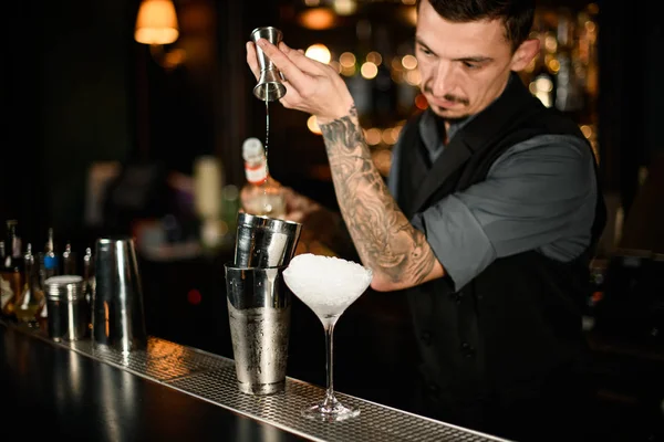 Barmen alkollü kokteyl bardağını jiggerdan çeliğe dolduruyor. — Stok fotoğraf