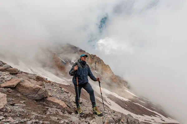 Maschio escursionista si trova su un lato della montagna — Foto Stock