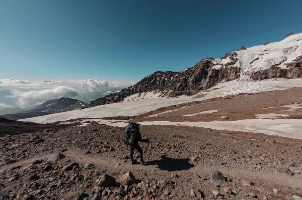 Caminante masculino se para frente a los lados de la montaña — Foto de Stock