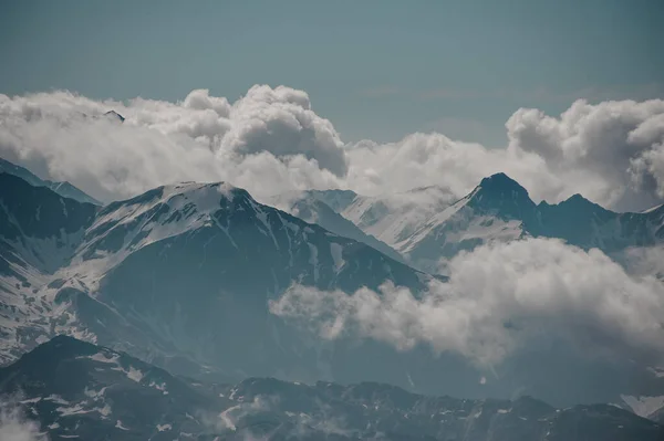 Landschap van bergtop gluren uit wolken — Stockfoto