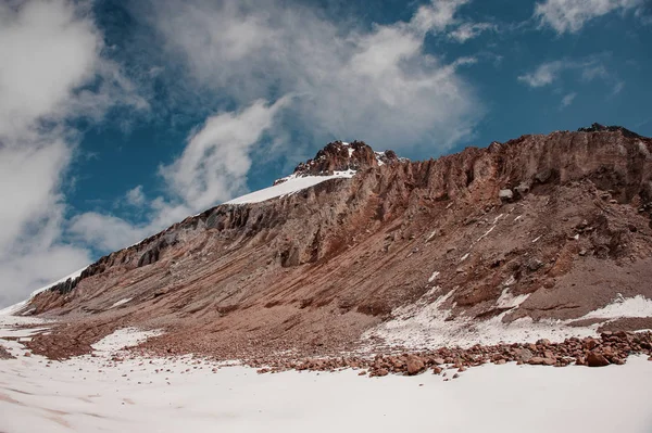 多云的天空下,平坦的山坡上覆盖着雪 — 图库照片