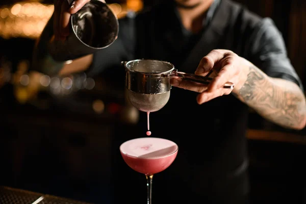 Close-up de bartender derramando coquetel com agitador e peneira — Fotografia de Stock