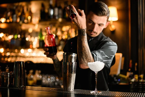 Erkek barmen, çelik jigger 'dan alkol kokteyli doldurur. — Stok fotoğraf