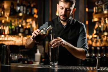 Erkek barmen alkolü şişeden zenciye döker.
