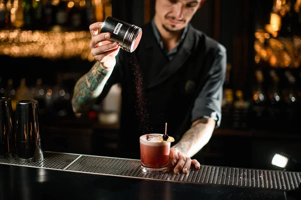 Man bartender förbereder alkohol dryck med hallon pulver — Stockfoto