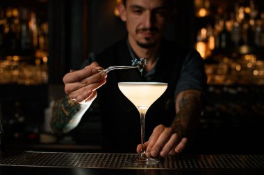 Erkek barmen alkolü küçük çiçeklerle süslüyor.