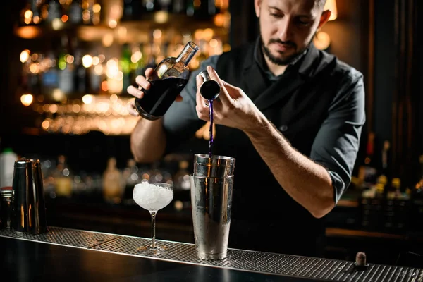Homem barman flui álcool roxo de jigger — Fotografia de Stock