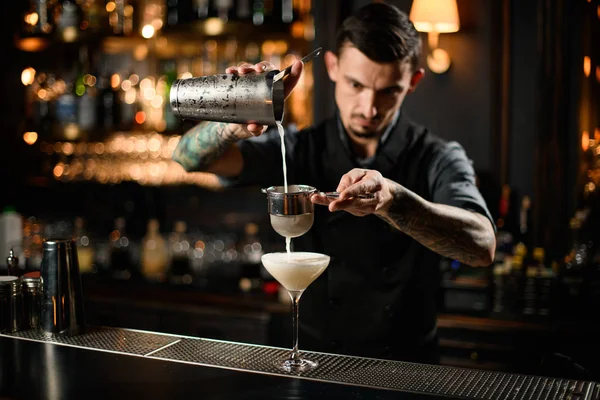 Homme barman flux alcool boisson à travers le tamis dans le verre — Photo