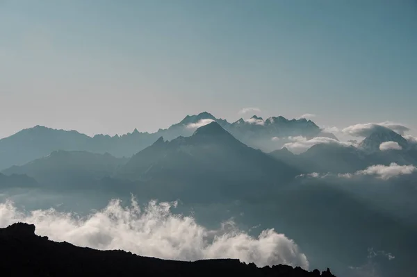 Bergheuvels onder blauwe lucht met witte wolken — Stockfoto