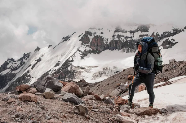 L'uomo in piedi sulla roccia intorno ai resti di neve in montagna — Foto Stock