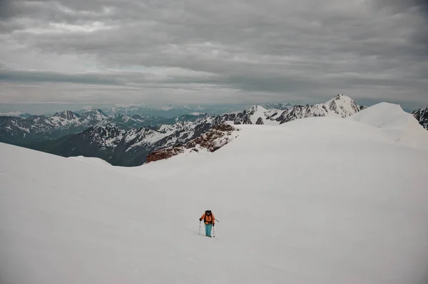 Ragazzo con attrezzatura da trekking arrampicata sulla neve sulla collina di montagna con bastoni e zaino — Foto Stock