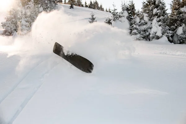 Snowboard caindo na neve em um dia ensolarado em montanhas — Fotografia de Stock