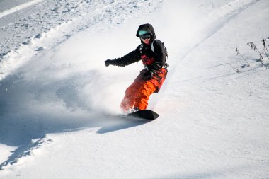 Profesyonel bir snowboard 'la dağdan kayan kız.