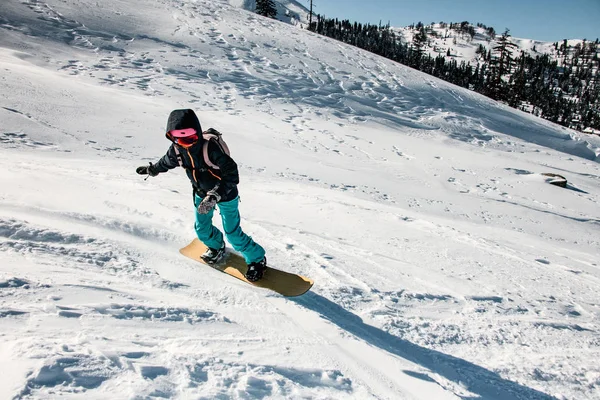 Mulher freeriding da montanha em um snowboard profissional — Fotografia de Stock