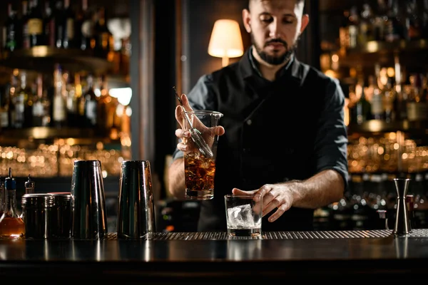 Cantinero macho hace bebida alcohólica con colador —  Fotos de Stock