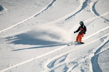 Profesyonel bir snowboard 'la dağdan kayan kadın.