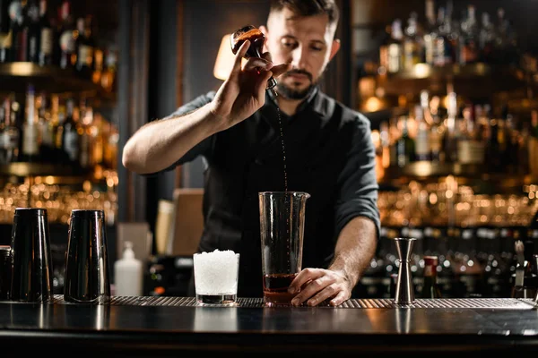 Erkek barmen bardağa ve şişeye kokteyl doldurur. — Stok fotoğraf